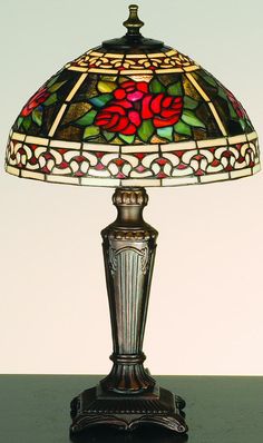 a stained glass lamp sitting on top of a table