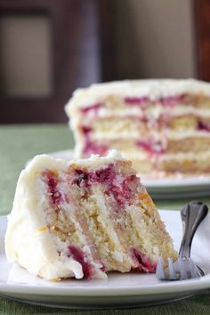 a slice of cake with white frosting and raspberry filling on a plate