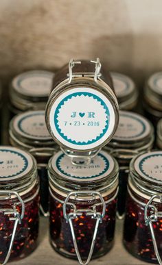 there are many jams in glass jars on the table with tags attached to them