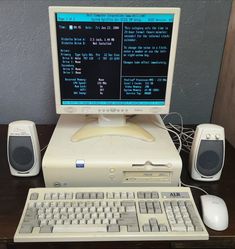 a desktop computer sitting on top of a desk next to two speakers and a keyboard