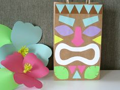 a paper bag with an image of a face on it next to flowers and decorations