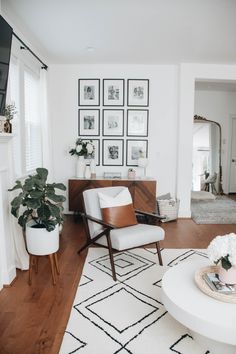 a living room filled with furniture and pictures on the wall