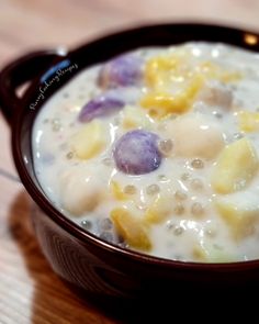 a bowl filled with cereal and fruit on top of a wooden table