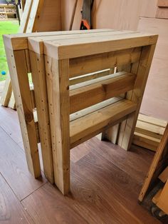 a bench made out of wooden planks sitting on top of a hard wood floor