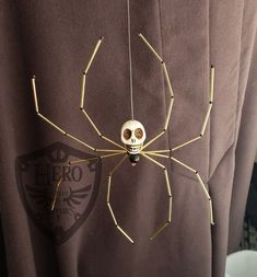 a spider with a skull on it's back hanging from a man's shirt