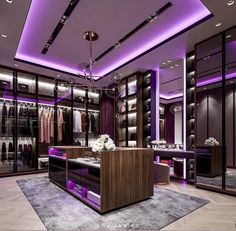 a large walk in closet with purple lighting