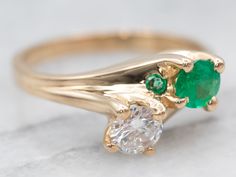 This bypass ring has a gorgeous silhouette! Great for an engagement, mother's, or anniversary piece, this ring features a vibrant emerald and diamond. Accented by a single emerald and diamond, this ring is ready to be dressed up or down!Metal: 14K Yellow GoldGem: Diamond .23 Carats, SI2 in Clarity, G in Color, Emerald .19 CaratsGem Measurements: 4.0 mm, RoundAccent: Emerald .01 Carats, Diamond .02 Carats, SI2 in Clarity, H in ColorRing Size: 4.75Marks: "14K" Stamped on the inside band Divorce Ring, Mothers Ring, Mother Rings, Bypass Ring, Ring Ideas, Rose Gold Band, White Gold Band, Gold Cross, Ring Diamond