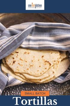 small batch tortillas in a bowl with a blue and white towel on top