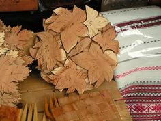 several wooden forks and spoons on a table next to some leaf shaped plates,