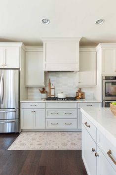 a kitchen with white cabinets and stainless steel appliances