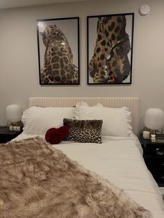 a bed with two pictures on the wall above it, and a leopard print pillow