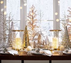 a table topped with candles and christmas trees