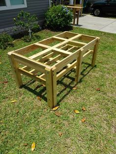 a wooden bed frame sitting in the grass