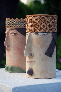 two vases with faces painted on them