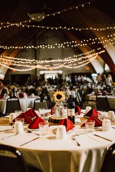 the tables are set with wine glasses and sunflowers