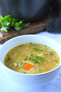 a bowl of soup with carrots and parsley