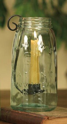 a glass jar with a candle inside sitting on a table