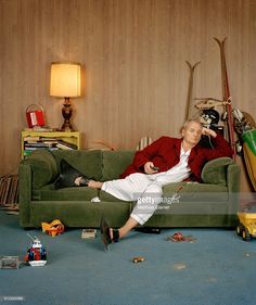 a man sitting on a green couch in a living room