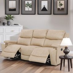 a beige reclining sofa sitting on top of a hard wood floor next to a lamp