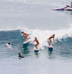 several surfers are riding the waves in the ocean, and one is on her surfboard