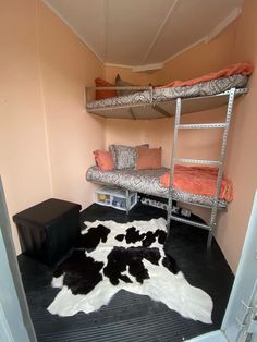 a bunk bed room with two beds and a cow hide rug