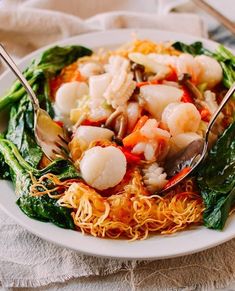 a white plate topped with noodles and shrimp