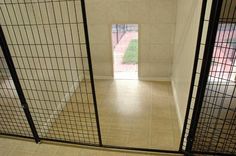 an open door in a room with tiled flooring and black iron bars on the doors