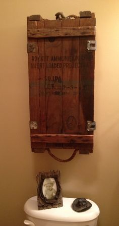 a toilet with a wooden box on the wall above it