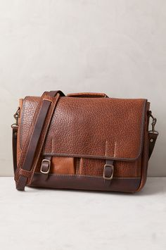 The Messenger Briefcase offers the ultimate leather bag that speaks volumes about your discriminating taste. Our classic briefcase design is handcrafted of shrunken bison leather boasting a premium rustic texture like no other leather. And it's contrasted by solid antiqued brass hardware and Horween Latigo leather straps that fasten the front flap over two roomy pockets, where you can slide your cell phone and keys. The tartan plaid-lined interior, featuring a snap pocket, and two open pockets f 39 Steps, Camping Vacation, Bison Leather, Rustic Texture, Luxury Business, Sheepskin Coat, Tartan Fabric, Antique Brass Hardware, The Messenger