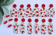 the watermelon earrings are decorated with gold and red beads, along with matching ear clips