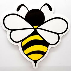 a yellow and black bee sticker sitting on top of a white table next to a wall