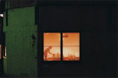 a man standing in front of a window at night