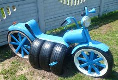 a blue tricycle sitting in the grass next to a fence