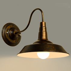 an old fashioned wall light with a white bulb on the side and a black arm