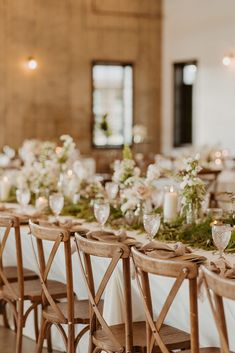 the table is set with white flowers and greenery for an elegant dinner or reception