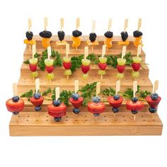 an assortment of fruits and vegetables on skewers with toothpicks in them