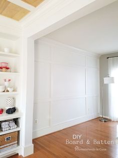 an empty room with white walls and wooden floors