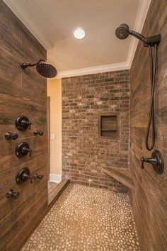 a walk in shower sitting inside of a bathroom next to a brick wall and tiled floor