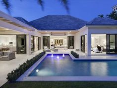 an outdoor living room and pool area at night