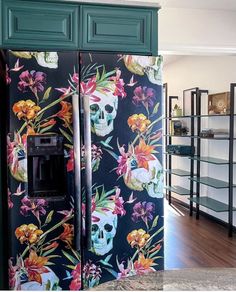 a colorful refrigerator covered in skulls and flowers