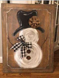 a wooden frame with a snowman painted on it