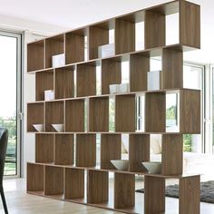 a large wooden book shelf sitting on top of a hard wood floor next to a dining room table