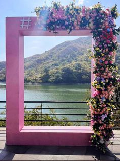 a pink frame with flowers on it near the water