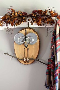 an owl mask is hanging on the wall next to a coat rack and plaid towels