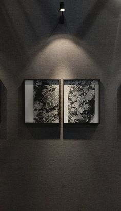 three black and white paintings hanging on the wall in a room with two lamps above them