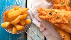 fried fish and fries on a blue wooden table