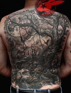 the back of a man's body with tattoos on it and trees in the background