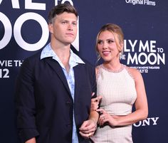 a man and woman standing next to each other on the red carpet at an event