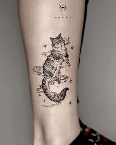 a woman's leg with a cat tattoo on it