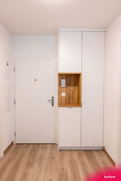 an empty room with wooden floors and white walls, has a door that is open